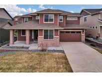Inviting two-story home with brick and siding, a welcoming front porch, and a two-car garage at 20830 Scenic Park Dr, Parker, CO 80138