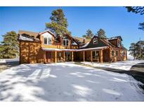 Mountain home exterior; log siding, multiple dormers, covered porch at 21531 Main Ave, Golden, CO 80401