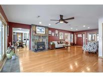 Spacious living room features a stone fireplace, ceiling fan, and hardwood floors at 21531 Main Ave, Golden, CO 80401