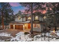 Stunning two-story home with a three-car garage, mature trees and winter landscape at 2492 Baldy Ln, Evergreen, CO 80439