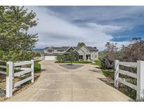 Stunning two-story home with circular driveway and white fencing at 7401 Deerfield Rd, Longmont, CO 80503