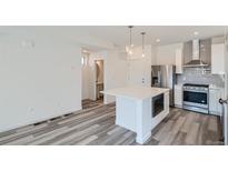 Modern kitchen with stainless steel appliances and island at 6906 Kendrick Ln, Arvada, CO 80007