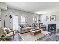 Bright living room with a fireplace, stylish furnishings, and a walk-out patio at 1202 S Troy St, Aurora, CO 80012