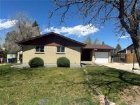 Charming single-story brick home with a well-maintained lawn and attached one car garage at 11623 E Virginia Dr, Aurora, CO 80012