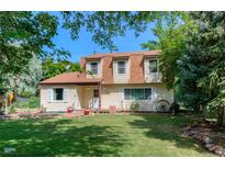 Charming two-story home with a lush lawn and mature trees shading the front yard at 1813 Pikes Peak St, Erie, CO 80516