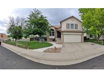 Charming two-story home featuring a manicured lawn, a two-car garage, and a welcoming front entrance with a beautiful walkway at 13008 Grove Way, Broomfield, CO 80020