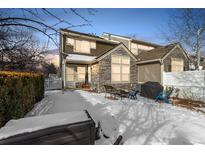 Snow-covered backyard with patio, grill, and seating area at 11235 Irving Dr # F, Westminster, CO 80031