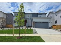 Contemporary two-story home with a manicured lawn, a driveway, and a two-car garage at 2560 Lupton Ln, Lafayette, CO 80026