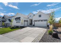 Attractive white home with a large driveway and two-car garage at 6456 Kenzie Cir, Castle Pines, CO 80108