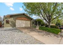 Charming brick home featuring a two-car garage and a well-manicured lawn at 2588 S Flower Ct, Lakewood, CO 80227