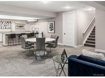 Finished basement with a wet bar, dining area, and staircase leading to the upper level at 6530 Barnstead Dr, Castle Pines, CO 80108