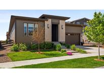 Modern home with a well-manicured lawn and beautiful landscaping adds curb appeal at 6530 Barnstead Dr, Castle Pines, CO 80108