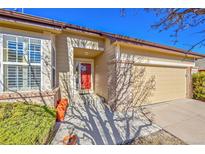 Charming home featuring a red front door, brick accents, and attached garage, creating a welcoming curb appeal at 16773 W 61St Ln, Arvada, CO 80403
