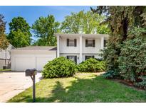 Charming two-story home with white exterior, well-manicured lawn, mature trees, and inviting curb appeal at 9540 E Grand Pl, Greenwood Village, CO 80111