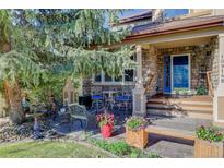 Inviting stone front porch with outdoor seating and well-maintained landscaping at 10914 W Coco Pl, Littleton, CO 80127