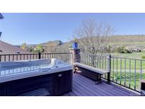 Outdoor hot tub on a deck with mountain and neighborhood views in the background at 10914 W Coco Pl, Littleton, CO 80127