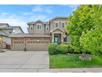 Charming two-story home with a three-car garage, covered entry, and well-manicured front lawn at 5161 Chicory Cir, Brighton, CO 80601