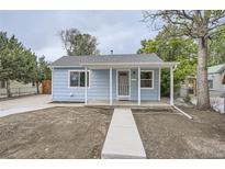 Charming blue single-story home featuring a cozy covered porch and freshly prepared landscaping at 233 N 10Th Ave, Brighton, CO 80601