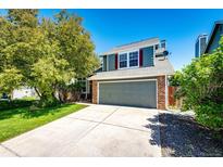 Two-story home with brick accents, gray garage door, and well-maintained lawn and mature trees at 4894 E Ashton Ave, Castle Rock, CO 80104