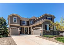 Beautiful two-story home featuring a three-car garage and a combination of siding and stone veneer at 25338 E Costilla Pl, Aurora, CO 80016