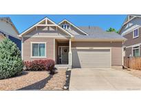 Charming single-Gathering home with a well-maintained front yard and two-car garage on a sunny day at 10639 Worchester Dr, Commerce City, CO 80022