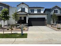 Modern two-story home with a two-car garage, white siding, and black trim, complemented by a well-maintained front yard at 2161 Flower Blossom Ave, Brighton, CO 80601