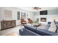 Bright living room featuring a fireplace, two armchairs, neutral carpet and a comfortable couch at 7974 S Pennsylvania Dr, Littleton, CO 80122