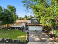 Charming two-story home boasts a well-manicured lawn and two-car garage at 9591 W Florida Pl, Lakewood, CO 80232