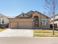 Inviting home featuring a two-car garage, beautiful architecture, manicured lawn, and an appealing front entrance at 5541 S Eaton St, Littleton, CO 80123