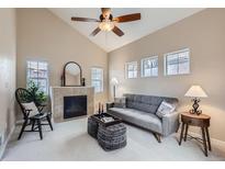 Bright living room boasts a fireplace, vaulted ceiling, neutral tones and a ceiling fan at 10148 E 29Th Dr, Denver, CO 80238