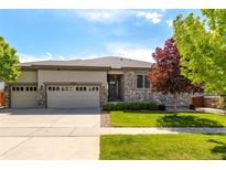 Charming single-story home with stone accents, three-car garage, and well-manicured lawn at 6265 S Ider Way, Aurora, CO 80016