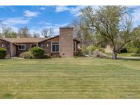 Charming home with a well-manicured lawn and beautiful stone chimney, offering great curb appeal at 2837 Reed St, Wheat Ridge, CO 80033