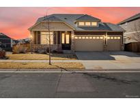 Charming two-story home with a three-car garage, stone accents, and a well-maintained lawn at 4837 S Buchanan St, Aurora, CO 80016