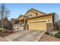 Inviting two-story home featuring a covered front porch, stone accents, and a two-car garage at 2872 Dreamcatcher Loop, Castle Rock, CO 80109