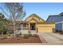 Charming yellow single-Gathering home boasts a welcoming front porch and a two-car attached garage at 2872 Dreamcatcher Loop, Castle Rock, CO 80109