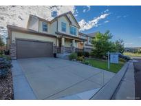 Charming two-story home with a well-manicured lawn and inviting front porch; For Sale sign in the yard at 651 Tiger Lily Way, Highlands Ranch, CO 80126