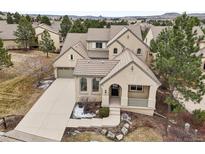 Attractive single-Gathering home showcasing beige stucco, clay tile roof, and a well-manicured lawn at 5035 Vermillion Dr, Castle Rock, CO 80108
