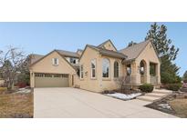 Inviting home featuring a tan stucco exterior, tile roof, attached garage, and manicured landscaping at 5035 Vermillion Dr, Castle Rock, CO 80108