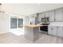 Modern kitchen with gray cabinets, butcher block island, and stainless steel appliances at 1020 Stuart St, Denver, CO 80204