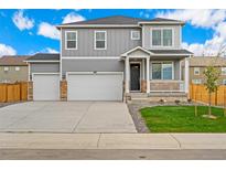 Two-story home with gray siding, three-car garage, and landscaped lawn at 4207 Sandstone Dr, Mead, CO 80504