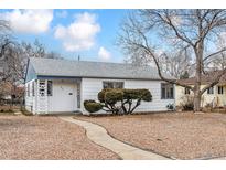 Charming single story home with gravel yard and walkway on a sunny day at 823 S Umatilla Way, Denver, CO 80223