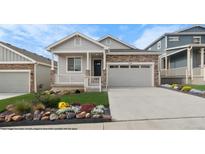 Charming home featuring stone accents, a covered porch, a landscaped yard, and an attached two-car garage at 2143 Peralta Loop, Castle Rock, CO 80104