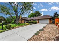 Charming single-story home with a well-manicured lawn, mature tree, and an extended driveway leading to a two-car garage at 11224 W 28Th Pl, Lakewood, CO 80215