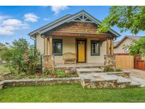 Charming home showcasing a welcoming front porch, stone accents, and a beautifully landscaped front yard at 4716 Broadway, Denver, CO 80216