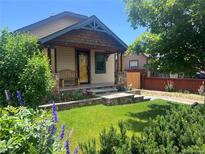 Charming home featuring a landscaped front yard, inviting porch with stone accents, and a cozy bench at 4716 Broadway, Denver, CO 80216