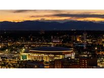 Nighttime aerial view showcasing the cityscape with lit arenas against a mountain backdrop at 1133 14Th St # 1850, Denver, CO 80202