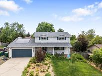Charming two-story home with a well-manicured lawn, solar panels, and a two-car garage at 915 Mercury Cir, Littleton, CO 80124
