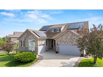 Beautiful stone and siding home featuring solar panels and a well-maintained front yard at 1752 Peninsula Cir, Castle Rock, CO 80104