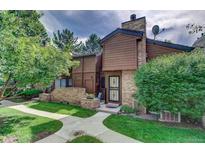 Exterior view of a brown townhouse with a brick walkway and landscaping at 2685 S Dayton Way # 292, Denver, CO 80231