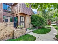 Inviting front entrance with brick accents, secure gate, and lush landscaping along the walkway at 2685 S Dayton Way # 292, Denver, CO 80231